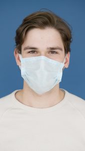 A man wears a protective face mask, adhering to pandemic guidelines.