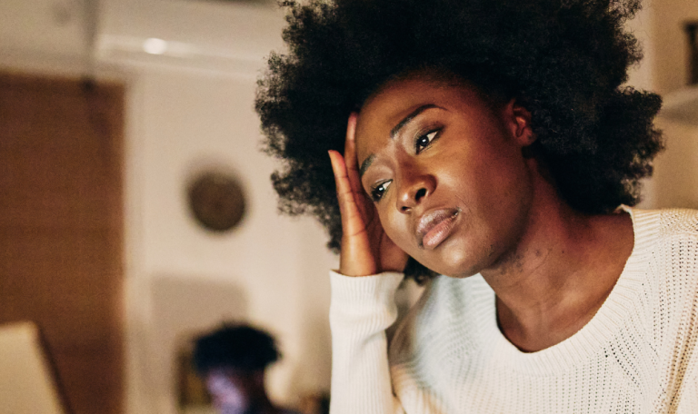 Tired black freelancer woman in co-working space.