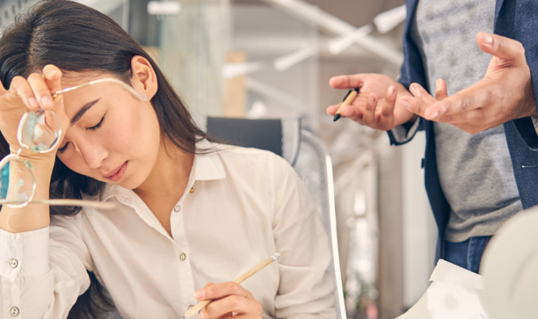 A visual representation of workplace stress with this image of a tired brunette woman at her desk.